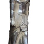 A standing statue with a human body and a lion's head